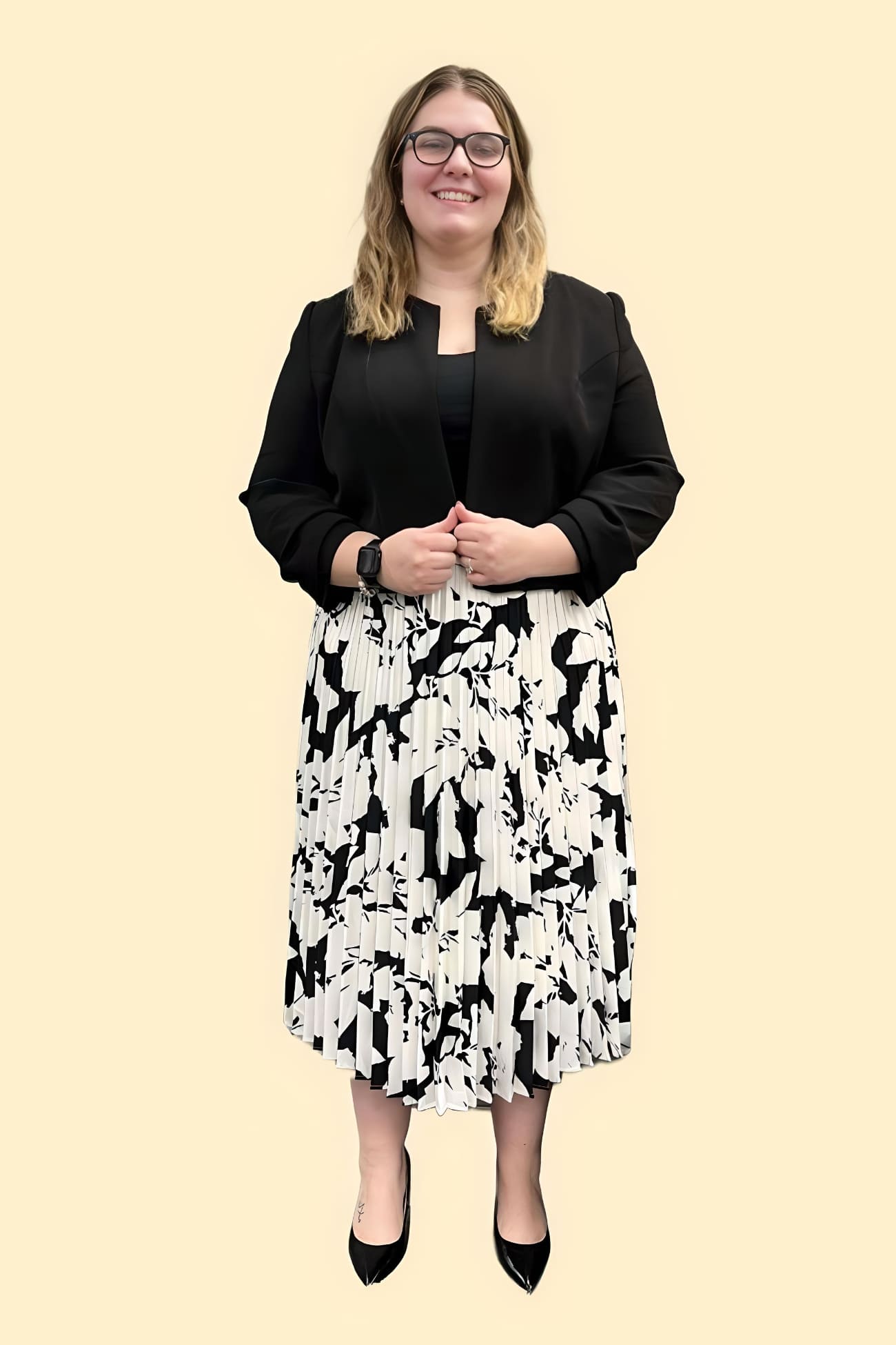 Katelyn Forbes, office manager, standing with an empathetic pose